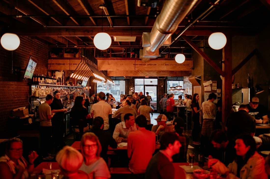 A busy, full restaurant dining room and bar in the evening